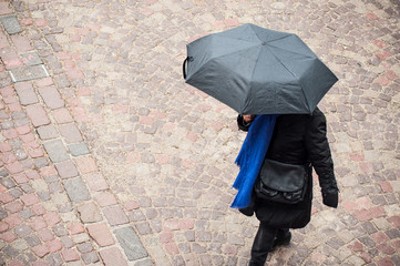  portrait of woman with umbrella on cobbles place in the city on top view