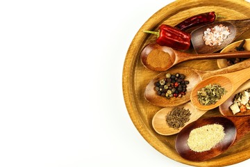Different spice types on a wooden spoon. Sale of spices. Spices on a white background.