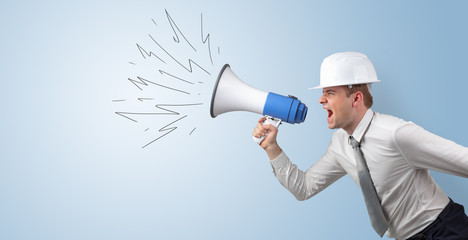 Fototapeta premium Young architect constructor yelling with megaphone and copyspace 