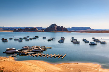 Boats on the Lake Powell, a reservoir on the Colorado River, straddling the border between Utah and Arizona. Popular tourist destination for cruises. - obrazy, fototapety, plakaty