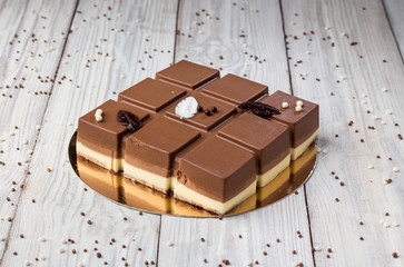 Dark chocolate vegan cake with candies on wooden background