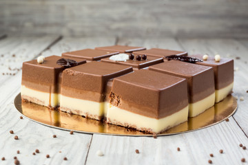 Dark chocolate vegan cake with candies on wooden background
