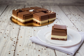 Dark chocolate vegan cake with candies on wooden background