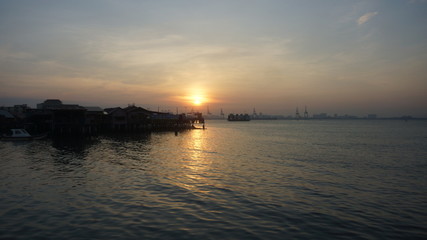 Naklejka na ściany i meble Beautiful silhouette during sunrise at Tan Jetty, George Town, Penang