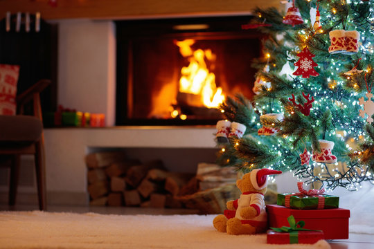 Christmas tree with presents at fire place.