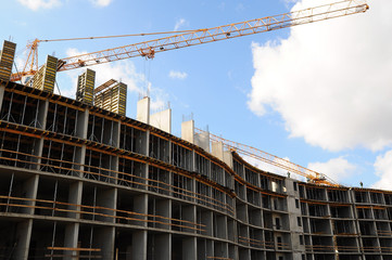 Crane and building under construction against blue sky