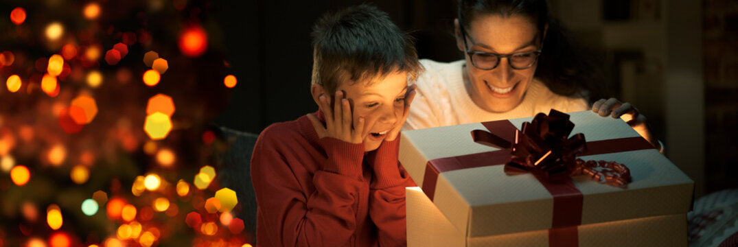 Boy and his mom opening a beautiful Christmas gift