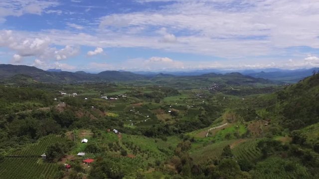Aerial drone shot flying over mountainous rural landscapes with scattered homes