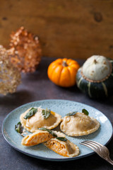 Fototapeta na wymiar Pumpkin and ricotta ravioli with crispy sage, burnt butter sauce and parmesan