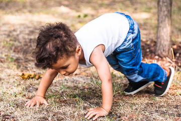 Little boy try to laying on grass in park for fun