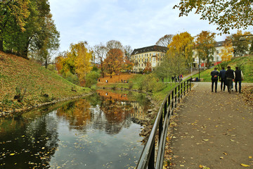 Fototapeta premium Walking path along the river in city in autumn. River Akerselva in Oslo, Norway.
