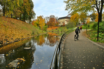 Walking path along the river in city in autumn. River Akerselva in Oslo, Norway. - obrazy, fototapety, plakaty