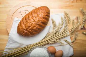 kitchen still life from flour, wheat ears, bread and eggs