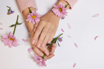 Naklejka na ściany i meble Fashion art skin care of hands and pink flowers in hands of women