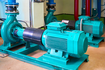 Blue engine with a pump standing on a metal stand.