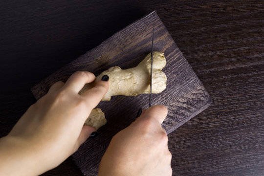 top view woman cut ginger on a wooden board