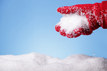 Hand in red gloves holding some snow