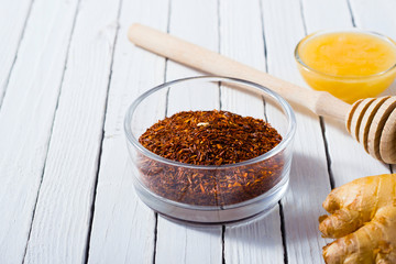 cup of tea, different leaves, honey, lemon ginger and brown sugar on white wooden table background