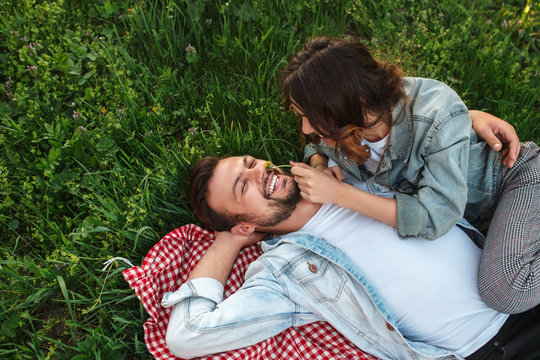 Woman Tickling Face Of Boyfriend In Nature