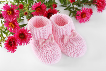 Pink little baby shoes with flowers on a white
