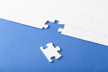 On a blue background, white puzzles and the missing piece