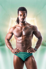 African American bodybuilder man, naked muscular torso, wearing bathing suit only, in futuristic...