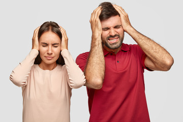 Photo of stressful depressed woman and man have terrible headache as work day and night, have...