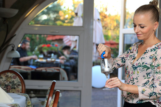Piękna dziewczyna, kelnerka zapala świecę w restauracji.