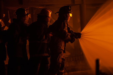 Fototapeta na wymiar JOHANNESBURG, SOUTH AFRICA - OCTOBER, 2018 Firefighters spraying down fire during firefighting training exercise