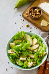 Pear Salad, Walnut, Camembert Cheese and Vinaigrette Dressing on stone table. Traditional french cuisine. Copy space.