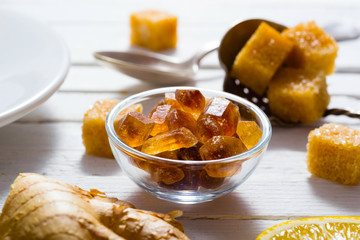 cup of tea, different leaves, honey, lemon ginger and brown sugar on white wooden table background
