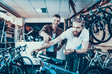 Consultant Shows Bicycle to Client in Sport Shop