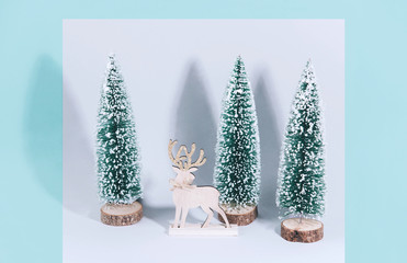 Christmas wooden tree with reindeer over light blue background.
