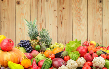 Panoramic photo healthy vegetables and fruits against wooden wall.