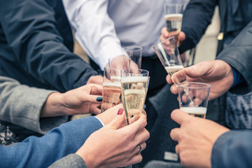 People celebrating a happy event clinking glasses of champagne,hands and glasses closeup.