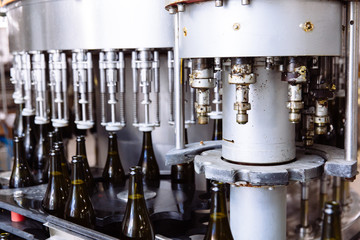 Glass bottles on the automatic conveyor line at the champagne or wine factory. Plant for bottling...