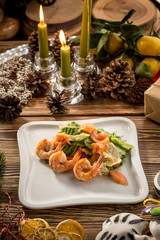 Fototapeta na wymiar Seafood Green Salad with Salmon, Avocado and Shrimps on white plate on christmas decorated background
