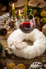 Glass of red wine on wooden table on christmas decorated background