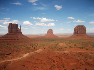 Fototapeta na wymiar Landscape monument valley (USA) against blue sky with clouds