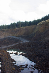 big pit in the forest for the extraction of ore