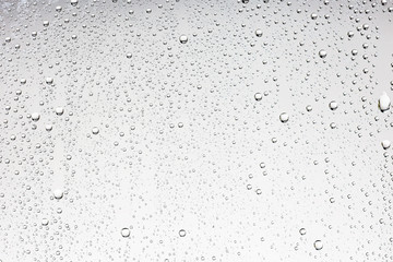 white isolated background water drops on the glass / wet window glass with splashes and drops of...