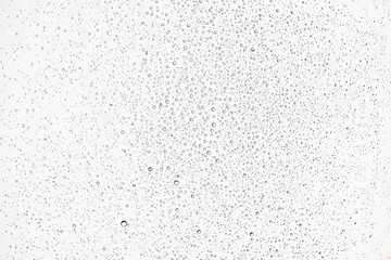 white isolated background water drops on the glass / wet window glass with splashes and drops of...