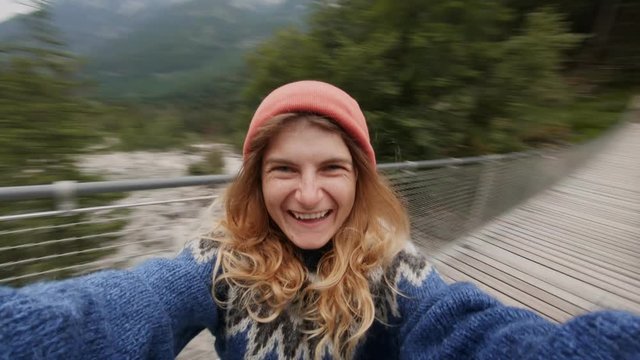 Happy, amused and excited laughing young pretty woman laughs and smies, holds camera and spins around, makes selfie video, travel around world, pursue dreams, adventure lifestyle