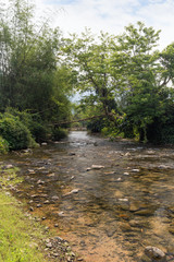 Beautiful view of a small and shallow river near Vang Vieng, Vientiane Province, Laos, on a sunny day.