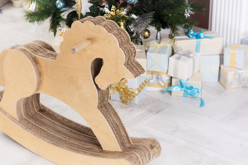 Fototapeta na wymiar Wooden horse. Gifts under the Christmas tree in the background
