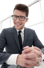 close up.smiling businessman sitting at his Desk