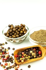 Pepper in wooden spoon. Mix of different peppers balls on white background. Sale of spices.