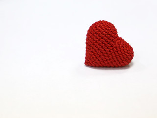 Red knitted heart isolated on white background. Concept for romantic love, blood donation, health care, Valentine's day