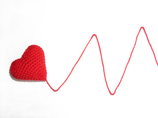 Red knitted heart with wool thread isolated on white background. Heartbeat sign, concept for heart rate, cardiogram, romantic love, heart disease, health care