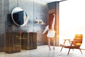 Double sink in concrete bathroom corner, woman